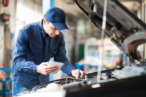 Mechanic using tablet in garage — Stock Photo, Image