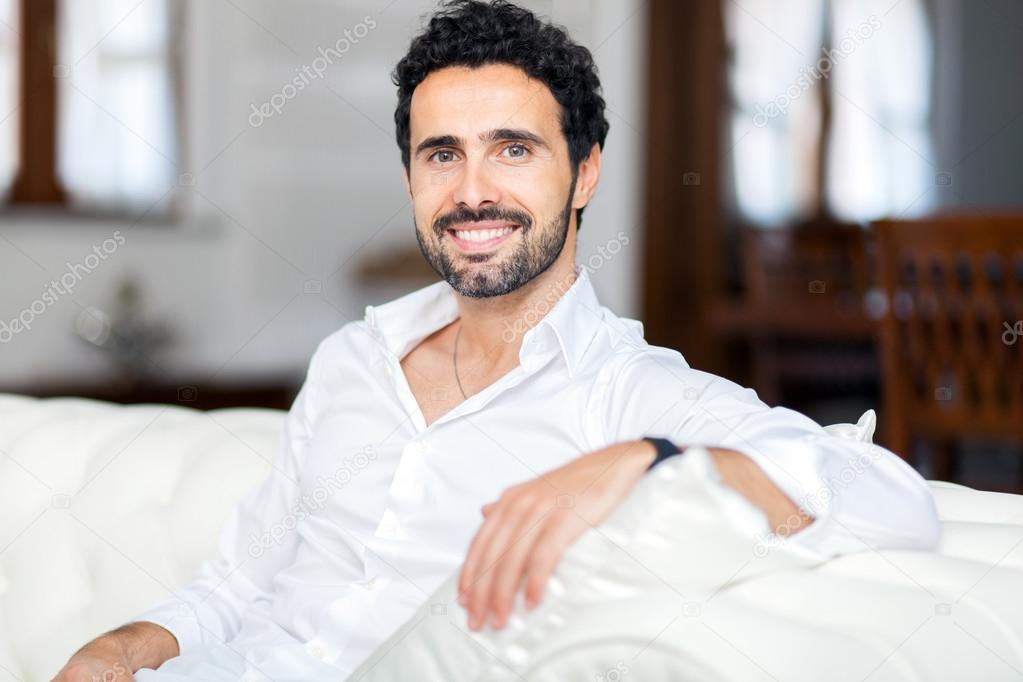man relaxing on couch in home