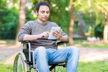man using a wheelchair in a park