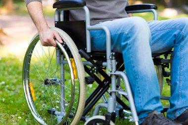 man using wheelchair in park clipart