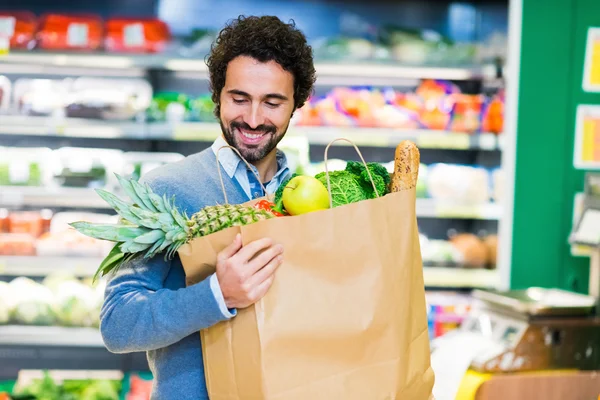 Homme regardant sac à provisions — Photo