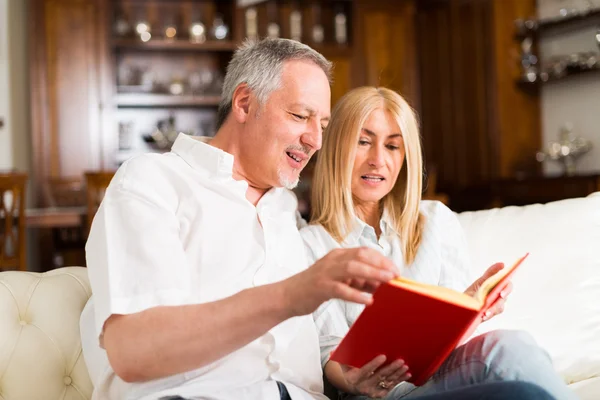 Felice coppia matura leggendo un libro — Foto Stock