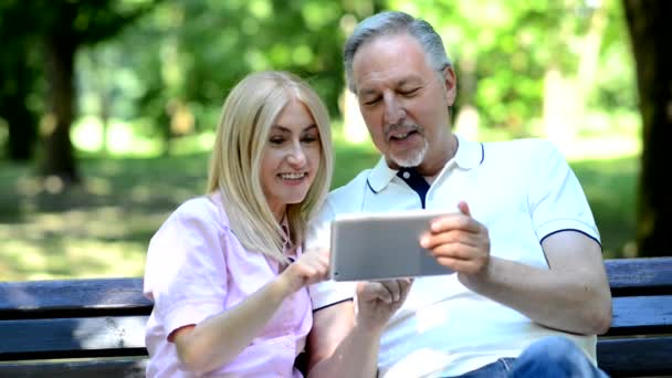 Met behulp van ouder paar tablet buiten — Stockvideo