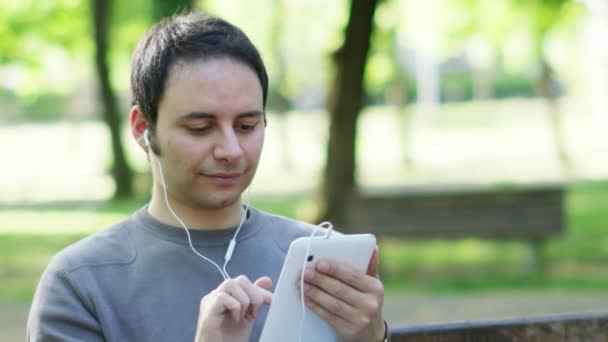 Людина використовує планшет для прослуховування музики — стокове відео