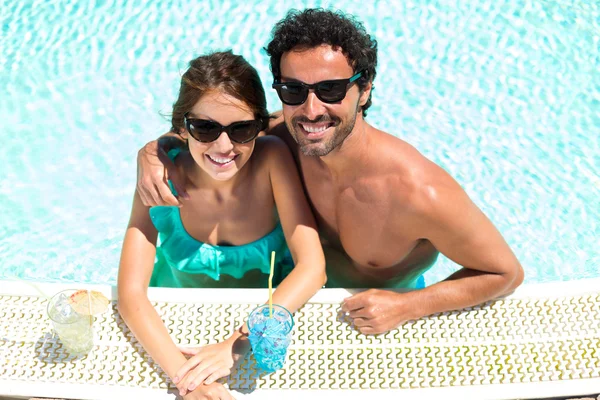 Casal desfrutando de um coquetel na beira da piscina — Fotografia de Stock