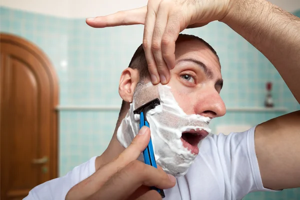 Man using razor to shave beard off — Stock Photo, Image