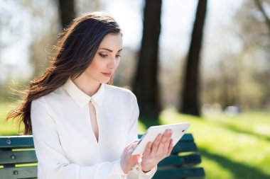 açık havada bir tablet kullanan kadın