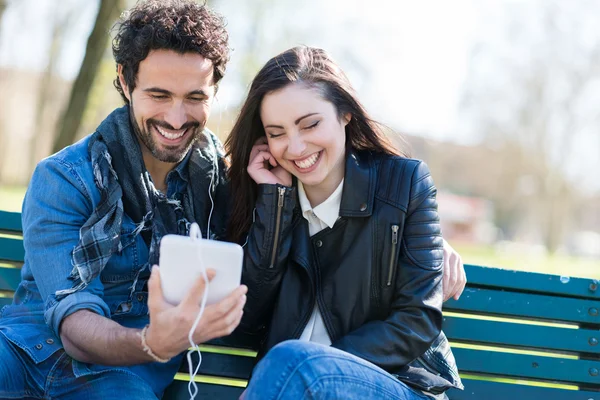 Coppia musica d'ascolto nel parco — Foto Stock