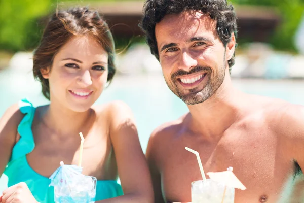 Couple boire un cocktail au bord de la piscine — Photo