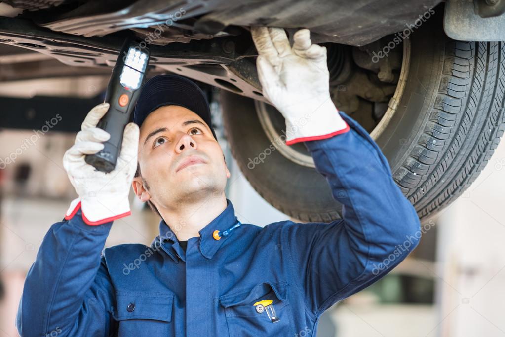 Mechanic inspect a lifted car — Stock Photo © minervastock 81628460