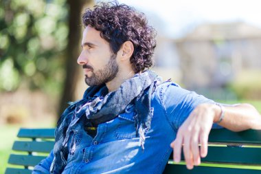 Parkta bankta oturan adam