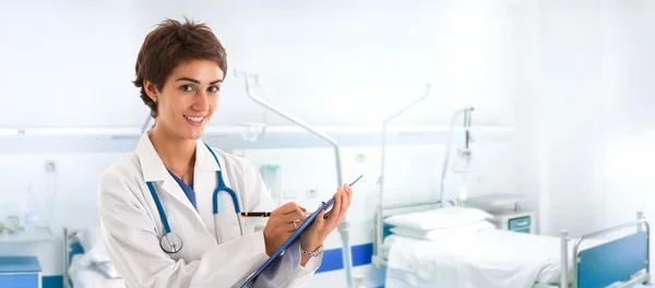 Doctor escribiendo en un portapapeles — Foto de Stock