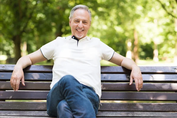 Mature man relaxing in a park — Stock Photo, Image