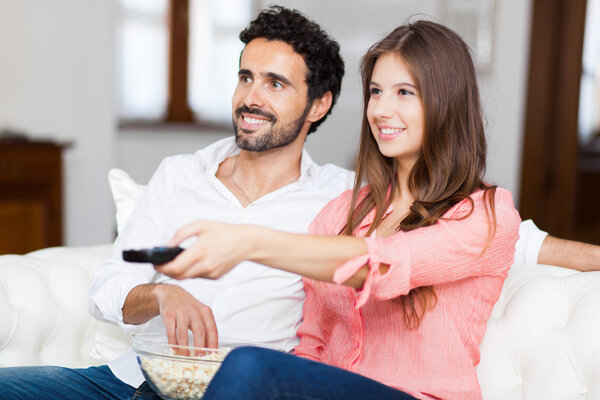 couple watching tv on a sofa