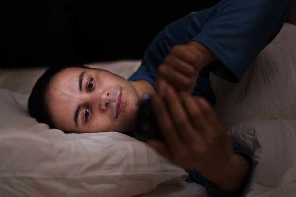 Man using his phone in bed