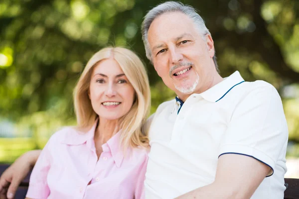 Mature couple sitting in a park — Stock Photo, Image