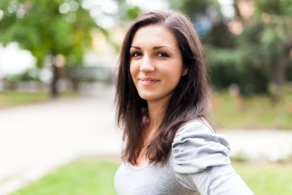 Leende kvinna i en park — Stockfoto