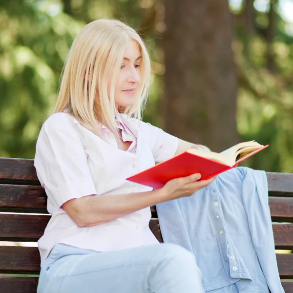 Gammal kvinna läser en bok — Stockfoto