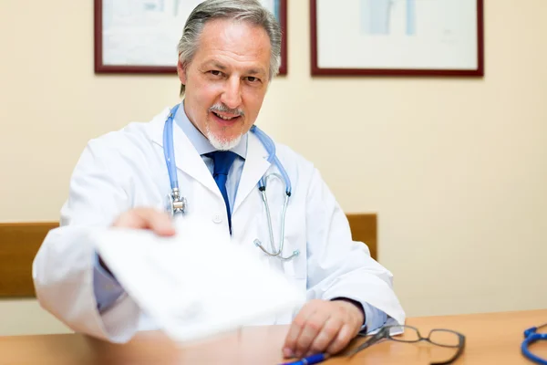 Médico maduro sentado en la mesa — Foto de Stock