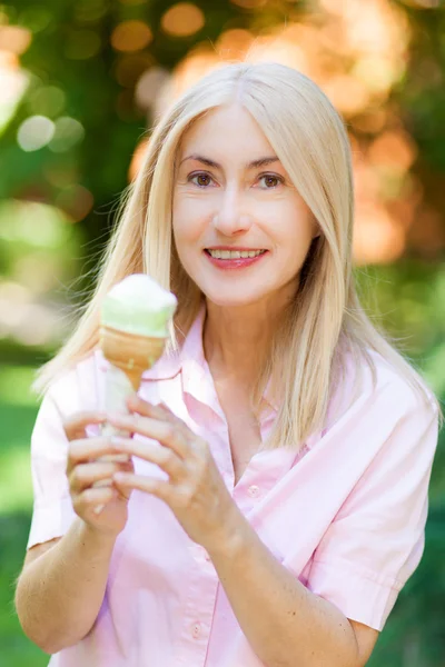 Donna matura mangiare un gelato — Foto Stock