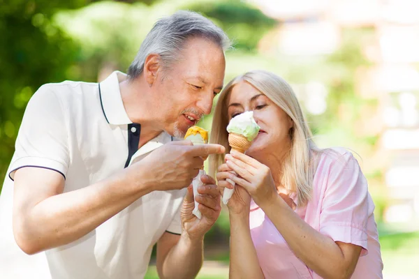 Pareja comiendo un helado en el parque — Foto de Stock