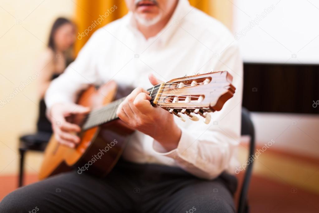 Man playing guitar in concert hall