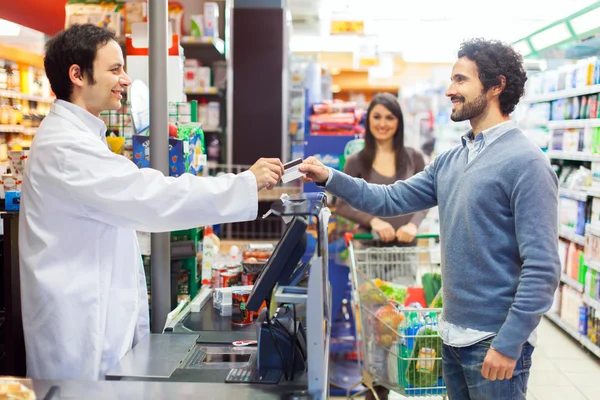 Klant bepalen met credit card te in supermarkt — Stockfoto