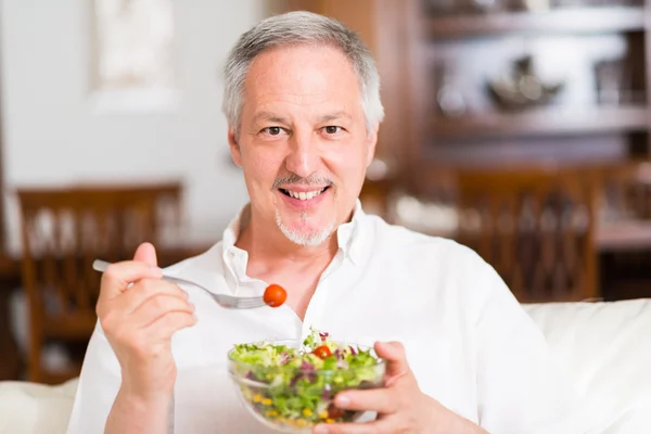 Homme mûr manger une salade — Photo