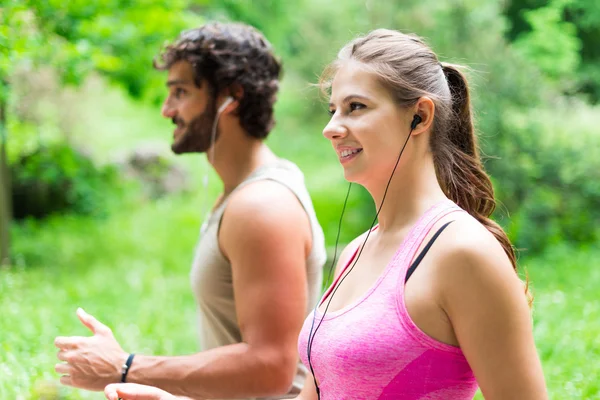 Couple running in a park — Stock Photo, Image