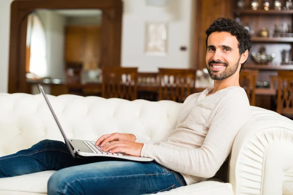 Man using laptop on couch — Stock Photo, Image