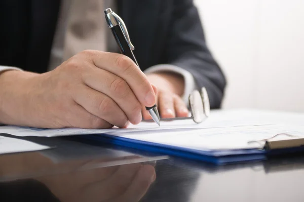 Empresario escribiendo en un documento — Foto de Stock