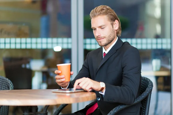 Empresario leyendo tableta durante el desayuno — Foto de Stock