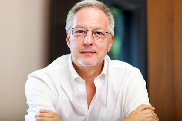 Reifer Mann sitzt im Büro — Stockfoto