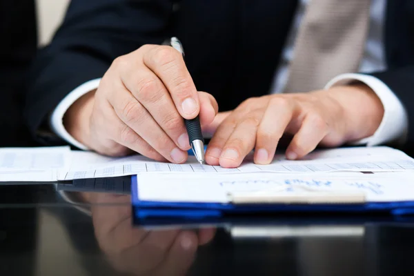 Un homme d'affaires rédige un document en fonction Photo De Stock