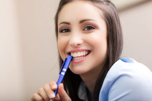 Mujer de negocios sonriente sosteniendo pluma —  Fotos de Stock