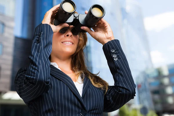 Mulher de negócios assistindo através de binóculos — Fotografia de Stock