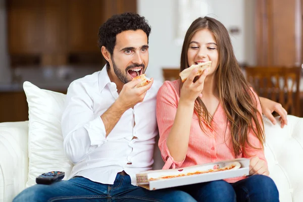 Couple avec pizza et télécommande TV — Photo