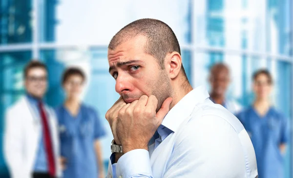 Scared guy in front of an hospital — Stock Photo, Image