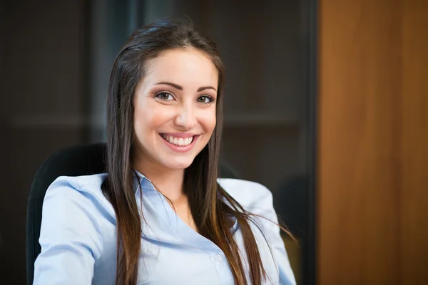 Lachende vrouw in haar kantoor — Stockfoto