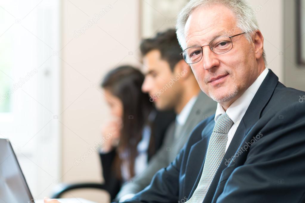 smiling businessman in front of team