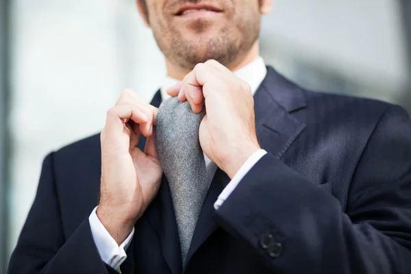 Businessman adjusting his tie — Stock Photo, Image