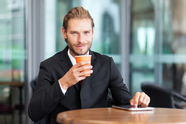 Empresario leyendo tableta y tomando café — Foto de Stock