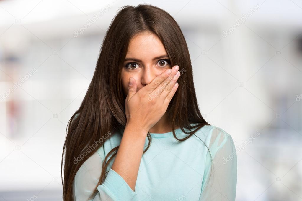 woman with her hand closing her mouth