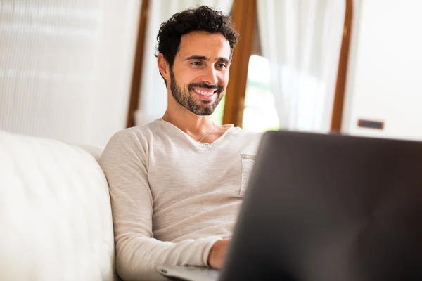 Homem usando laptop em seu apartamento — Fotografia de Stock