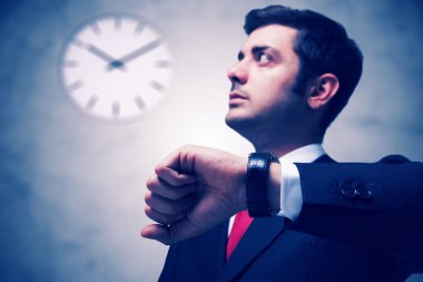 Businessman looking at watch clipart