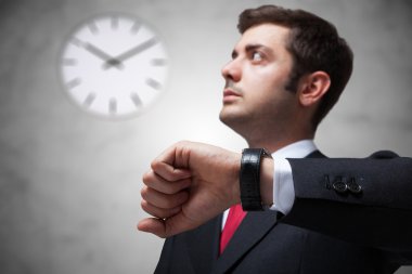 Businessman looking at watch clipart