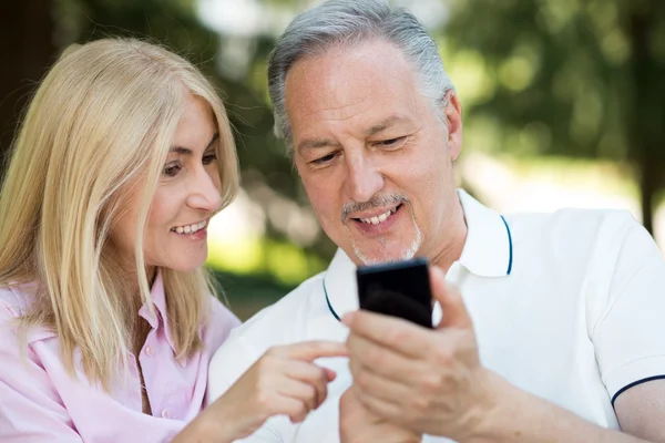 Man pokazano telefon komórkowy do żony — Zdjęcie stockowe