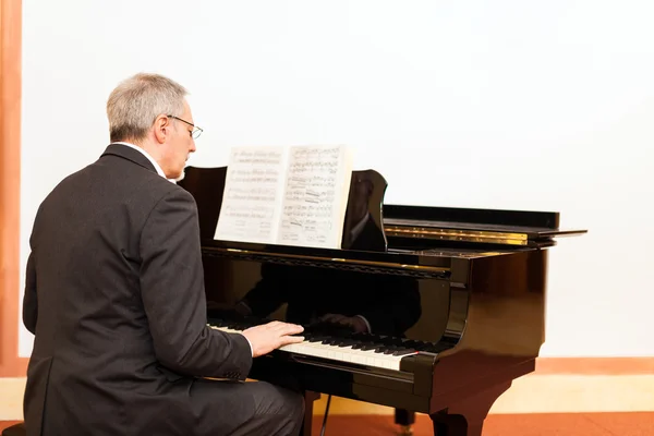 Homem tocando um piano — Fotografia de Stock