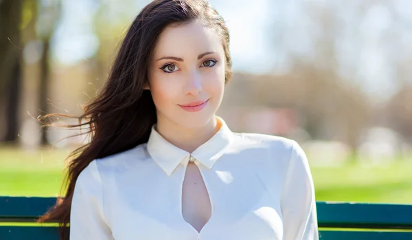 Young smiling woman in a park — Stock Photo, Image