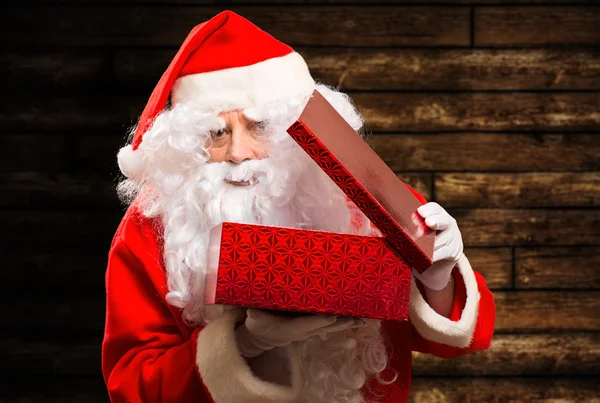 Weihnachtsmann beim Öffnen eines Geschenks — Stockfoto